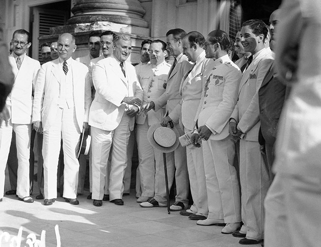 President Carlos Mendieta of Cuba, in white linen, exchanges greetings with U.S. Ambassador Jefferson Caffery in Havana upon hearing of the signing of the Cuban-American Treaty in Washington, May 31, 1934. 