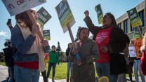 Magdaline Armstrong (right), a first-grade teacher, and her daughter Nilaya, eight, rally on a picket line with kindergarten teacher Grace Allen (left) outside Futures Elementary School.