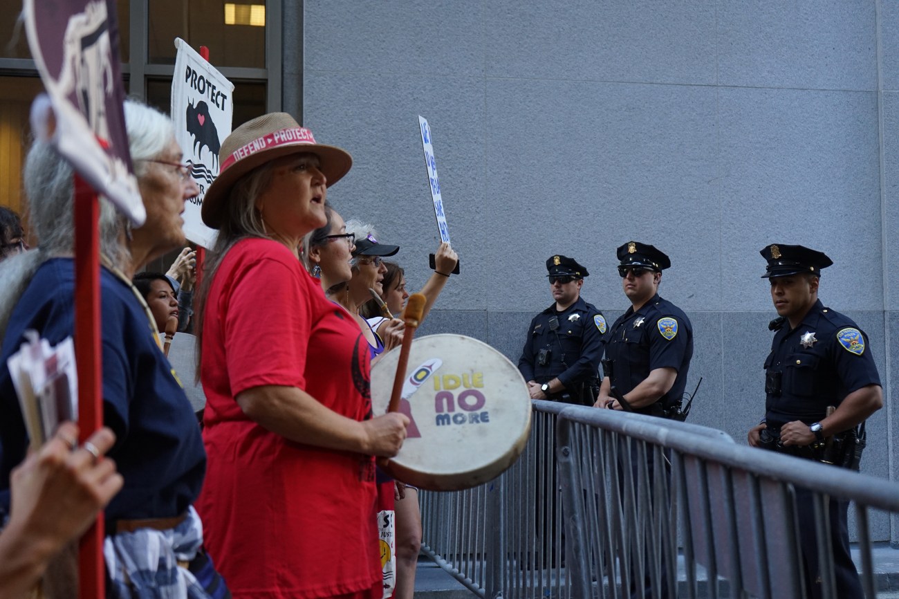 Pennie Opal Plant of Idle No More SF Bay leads songs and prayer outside of Wells Fargo.