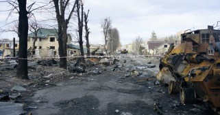 A street filled with ruble and destroyed military equipment.