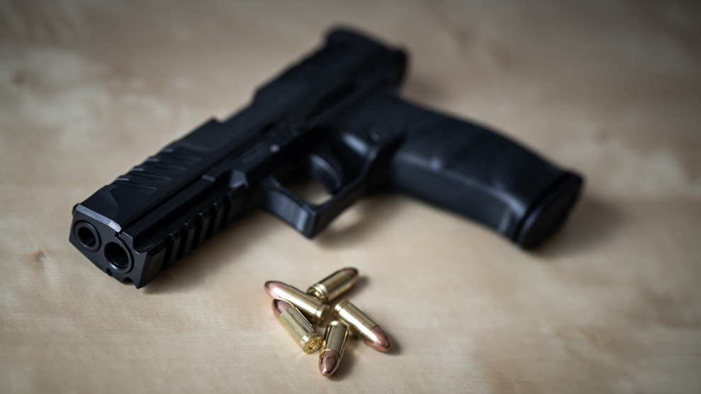 A 9mm handgun lies on a table with a small pile of cartridges.