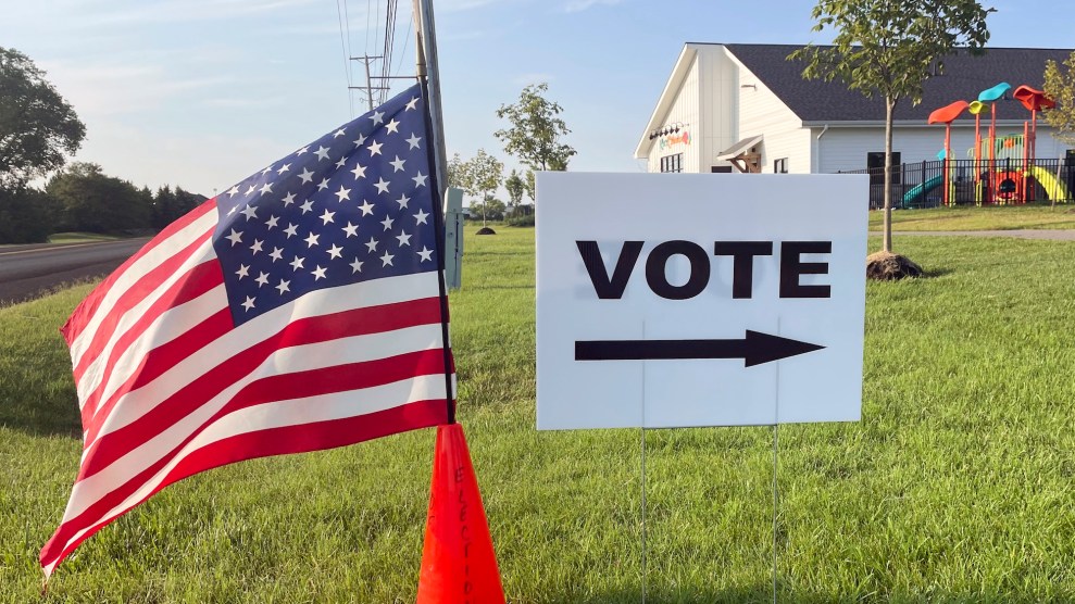 An American flag waves in the breeze next to a sign directing Ohioans to vote.