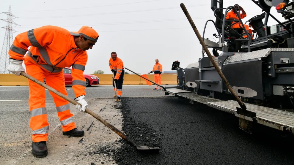 Workers in orange uniforms working with shovels