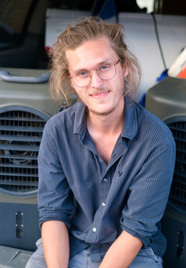 Man with glasses smiling at camera.