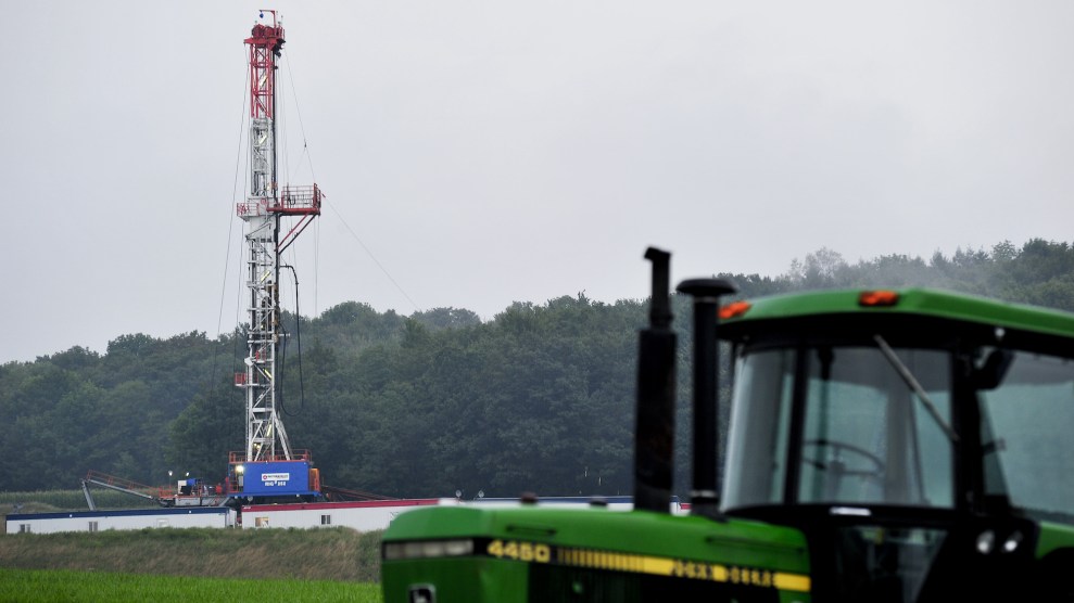 A red and white fracking equipment, with a green car in front