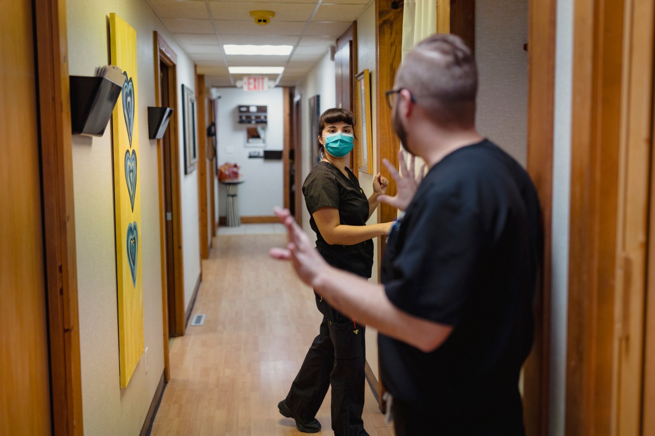 An operating room technician, listens to Dr. Aaron Campbell as they prepare for another patient at the Las Cruces Women's Health Organization.