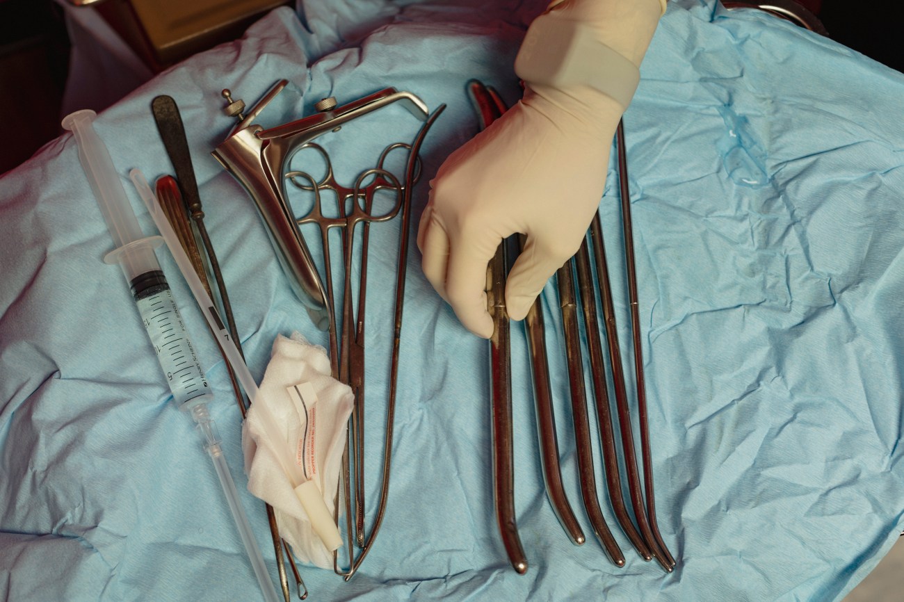 Hand of a doctor organizes medical tools prior to a procedure.