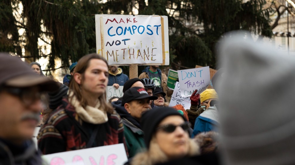 A crowd of people stands together, one person prominently holds a sign that says "Make Compost not Methane"