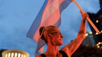 Cole Ramsey, 39, of South Linden holds a Transgender Pride Flag in front of the Ohio Statehouse to protest the passing of legislation against Trans Women playing sports in high school and college.