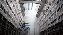 A worker installs a new row of Bitcoin mining machines at the Whinstone US Bitcoin mining facility in Rockdale, Texas.