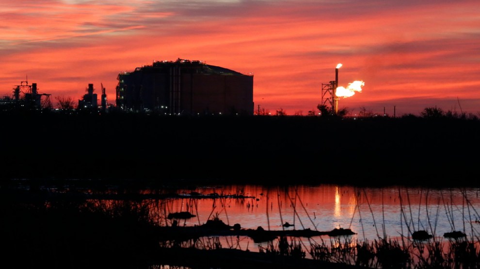 A LNG export facility sits in the distance with dark red skies