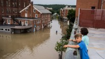 Two children look over a flooded street.