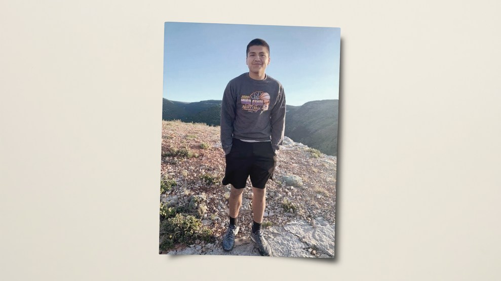 Photo of a boy smiling with his hands in his pockets.