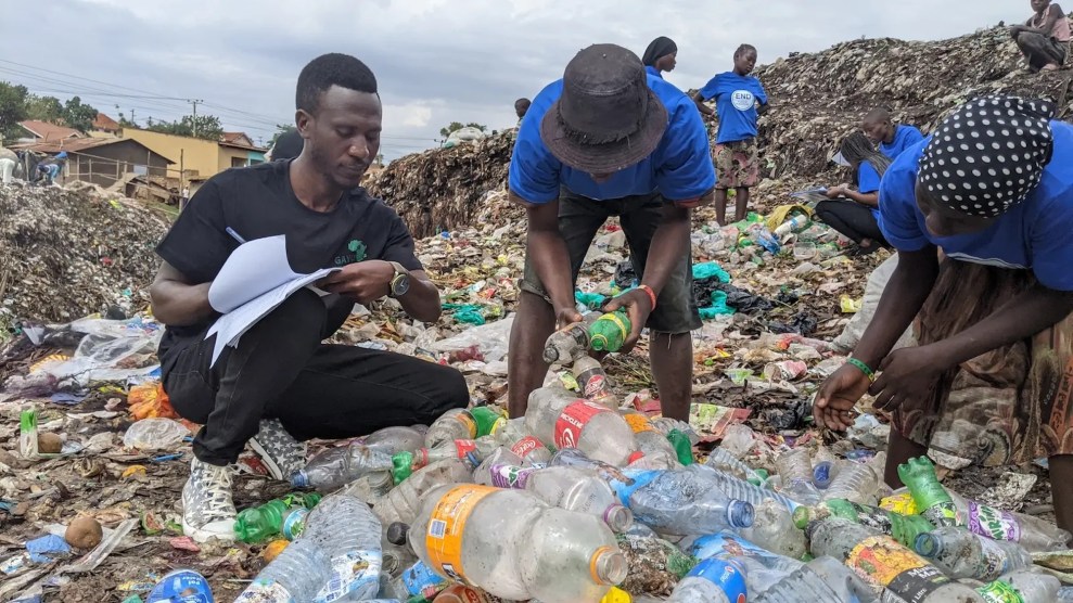 A group of black people looking at labels on plastic botels, with one person writing things down