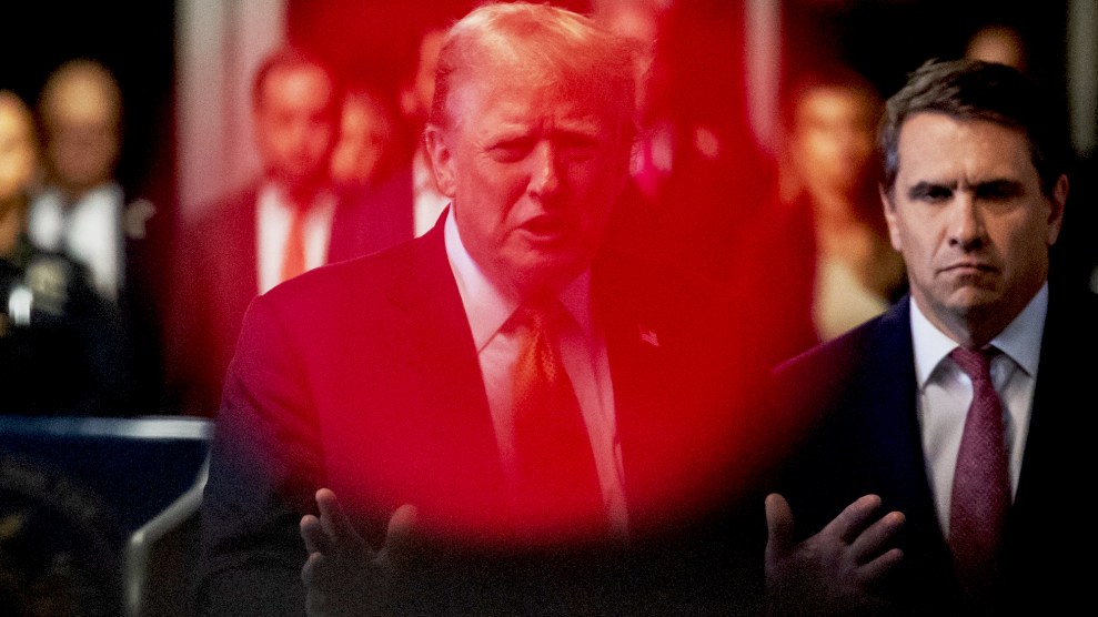 Donald Trump is centered in a red lens flare as he stands next to one of his attorneys, Todd Blanche. Trump addresses reporters outside of Manhattan criminal court.