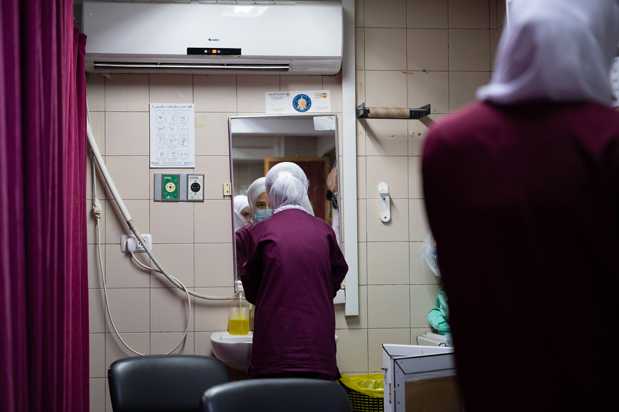 A woman looks at herself in a hospital mirror.