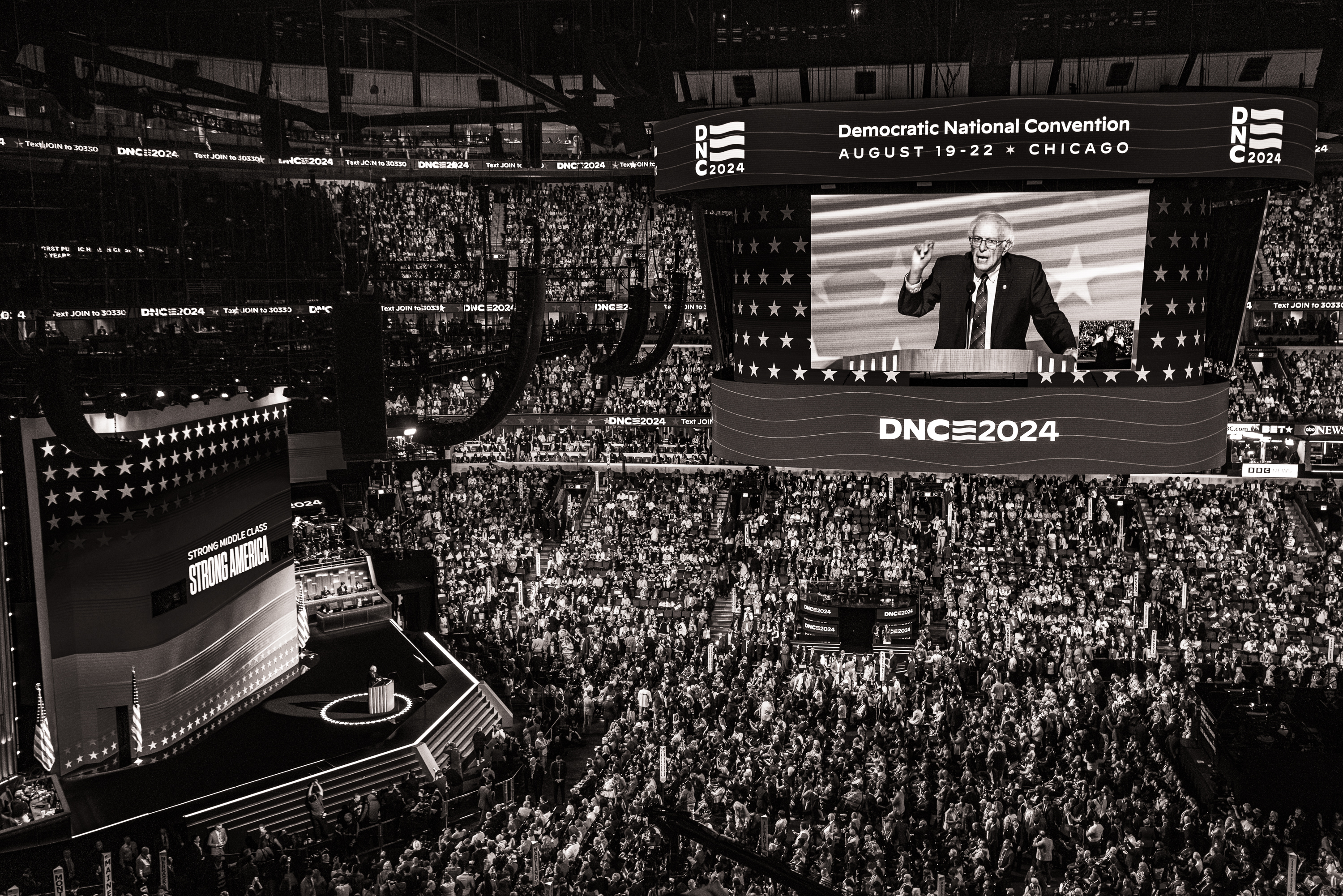 Black and white photo of the large crowd at the United Center during Senator Bernie Sanders' speech at the DNC.