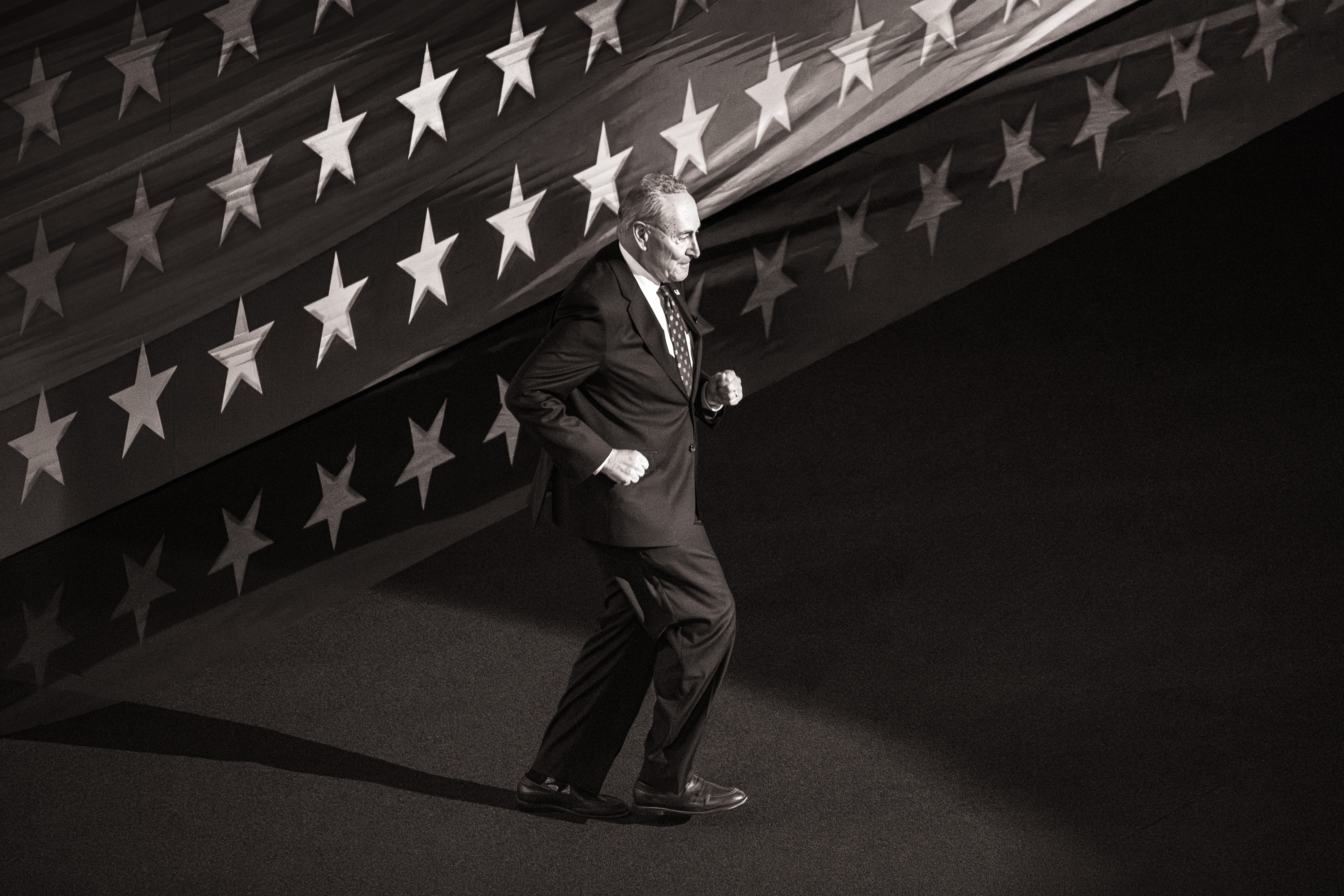 Black and white photo of Senator Charles Schumer dancing on stage at the DNC.