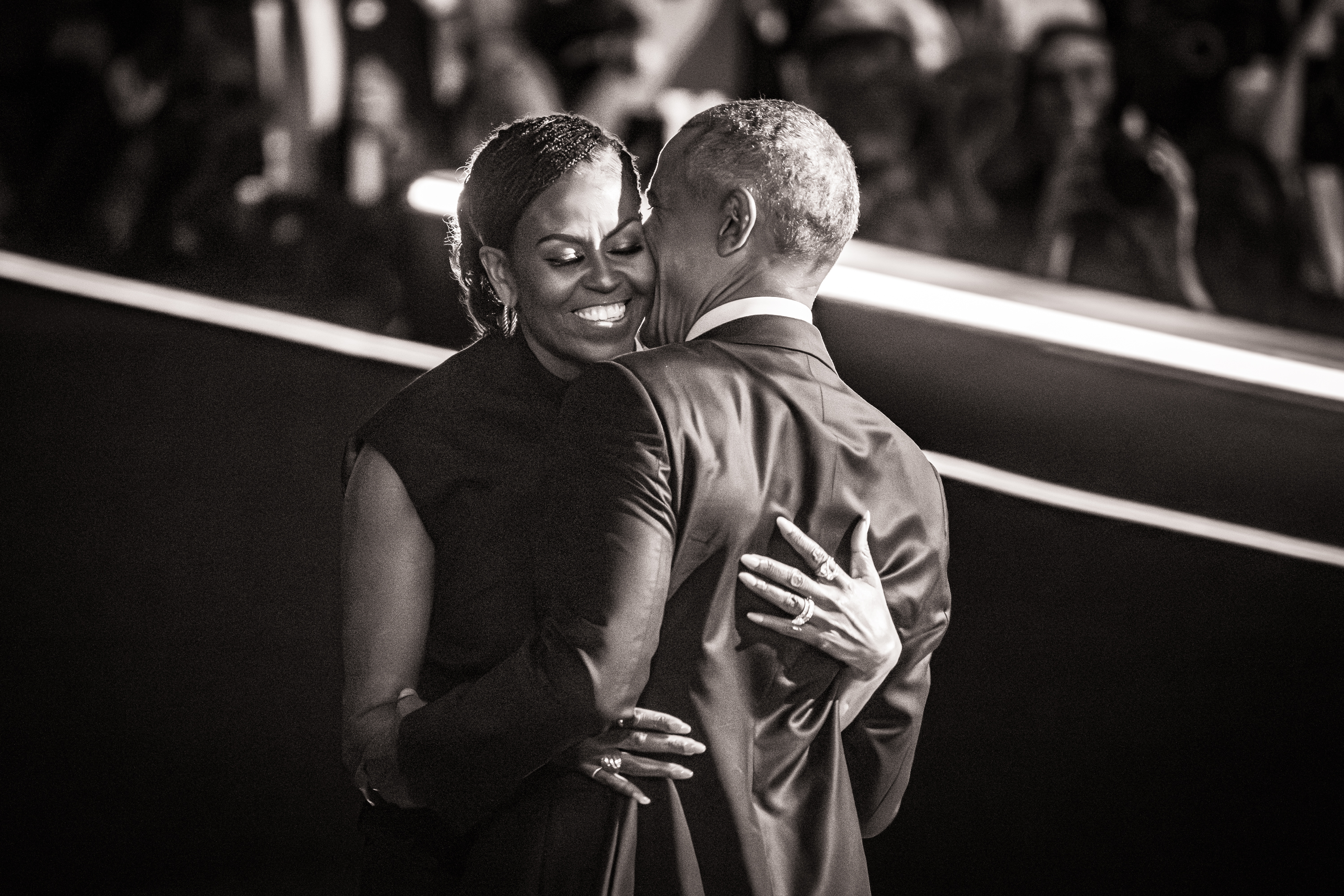 Black and white photo of Michelle and Barack Obama embracing.