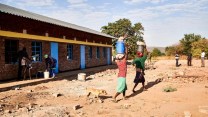 People move items on top of their heads to build a carbon credit project.