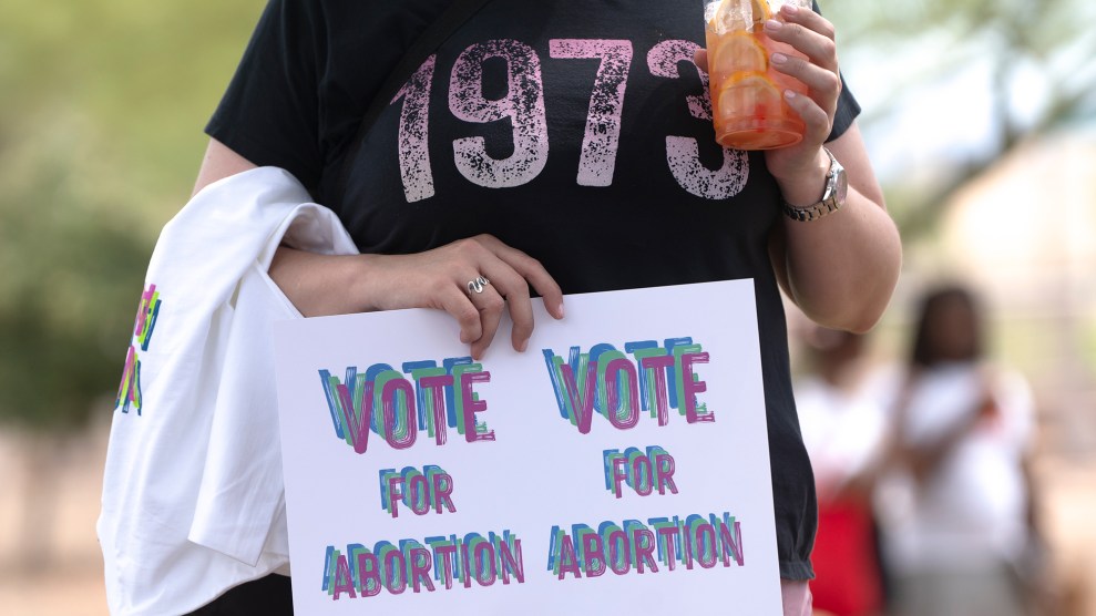 A person wearing a "1973" t-shirt and holding a sign that says "Vote for abortion."