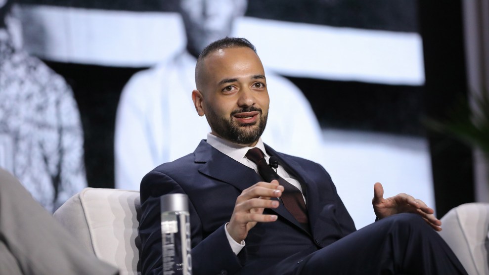 Murad Awawdeh sitting, speaking on stage.