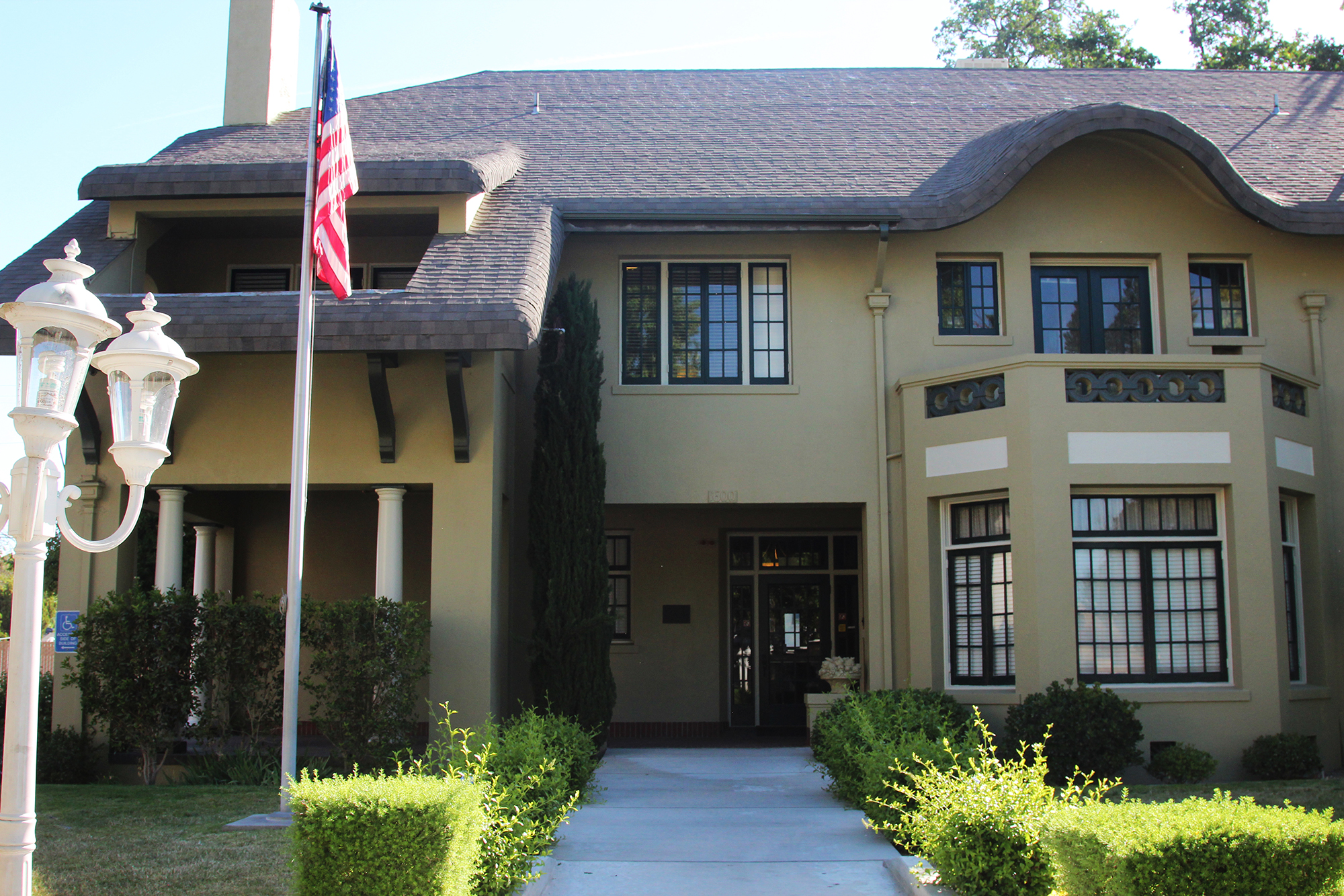 Exterior view of brown-color building with an American flag out front.