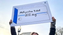 A supporter of abortion rights holds a sign in support of access to medication.