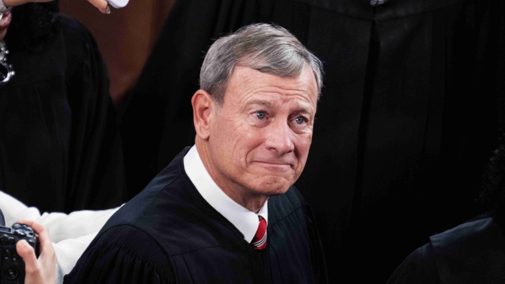 John Roberts, a white man with grey hair wearing a collared shirt and tie that is mostly covered by a black judicial robe.