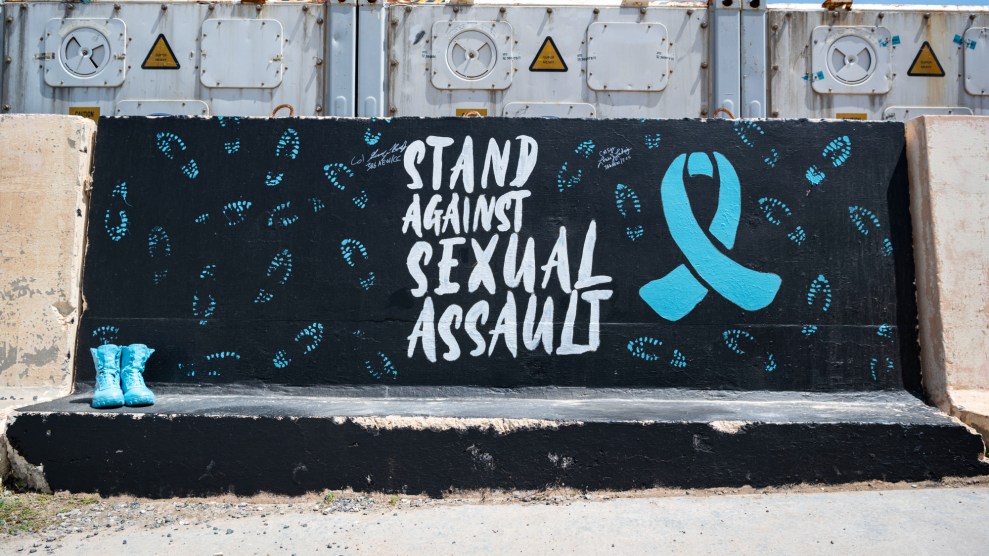 A mural with a black background has blue bootprints and a blue awarness ribbon. In white, it reads, "Stand against sexual assault."