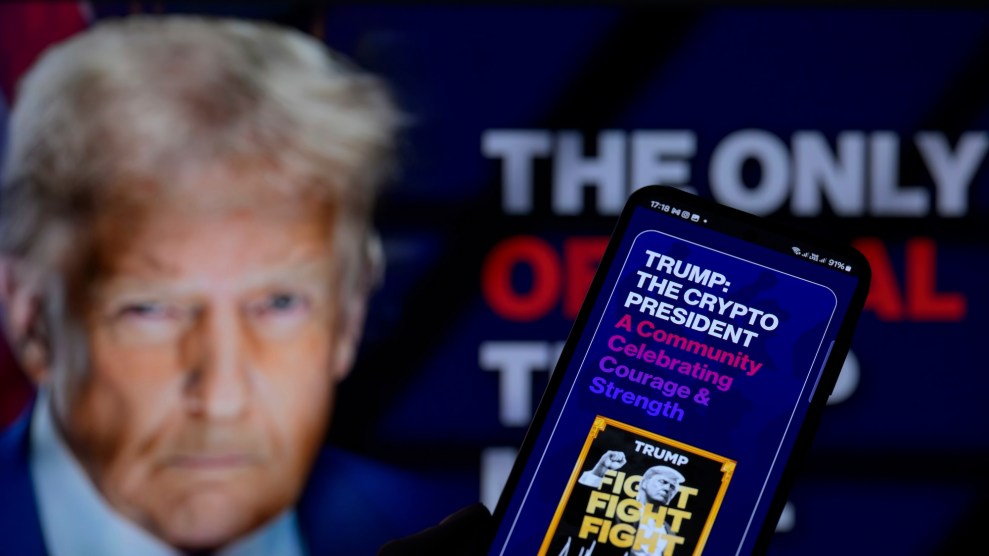 A cellphone in the foreground shows a screen that says, "Trump: The crypto president." Donald Trump's face is prominent but out of focus in the background.