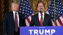 Hussain Sajwani stands on a Trump-branded podium, flanked by American flags. Donald Trump stands behind him to his right.