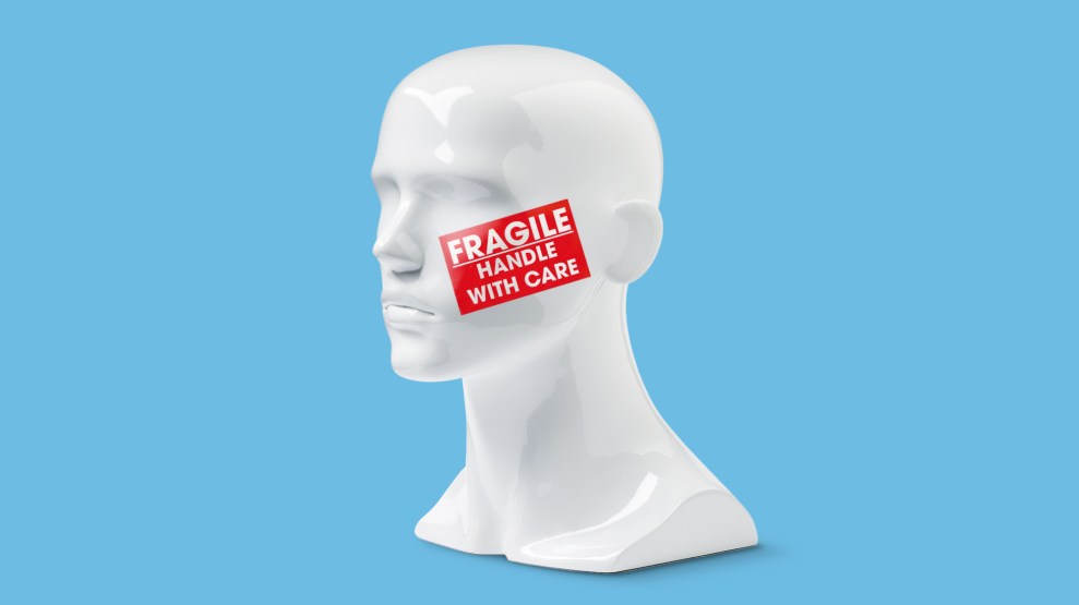 The bust of a white mannequin with a sticker on its cheek that says "FRAGILE HANDLE WITH CARE"