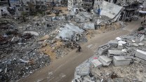 A dirt road cuts between rubble of two buildings in Gaza.