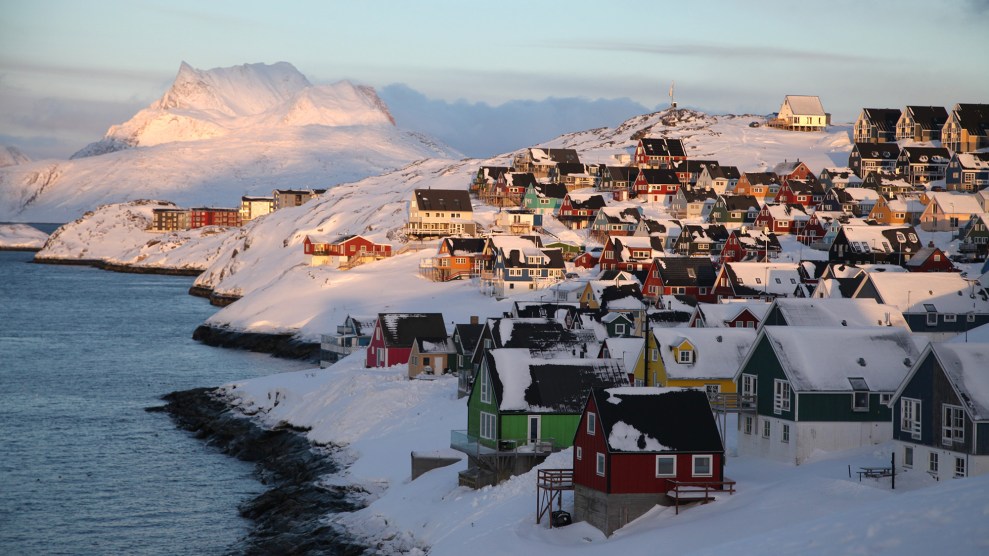 Houses covered in show are next to a blue shore.