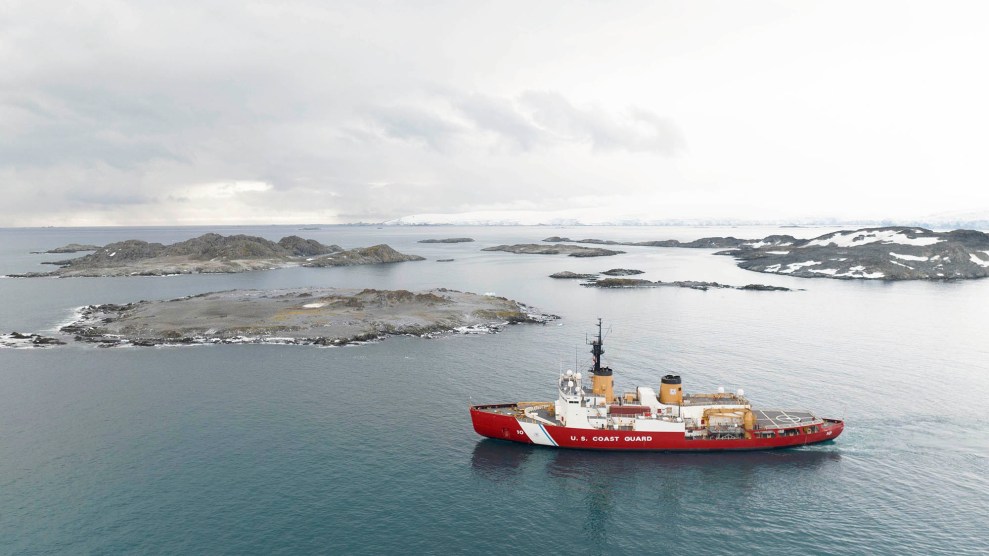 A red boat floats next several islands.