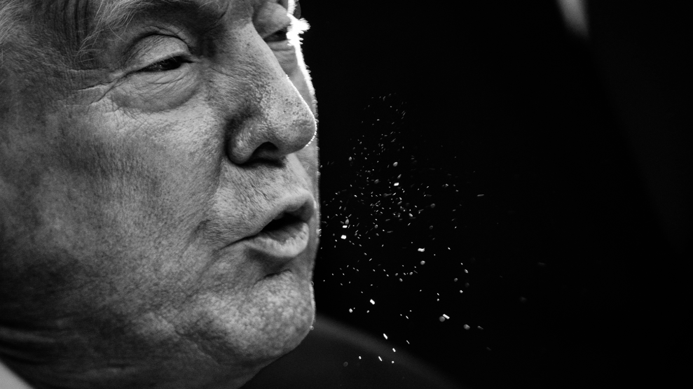 A tightly cropped portrait of Donald Trump's face with spittle shooting from his mouth to the right side of the photo.