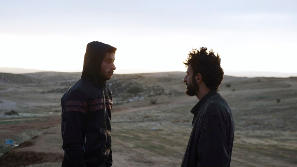 Two men standing, facing each other in a field.