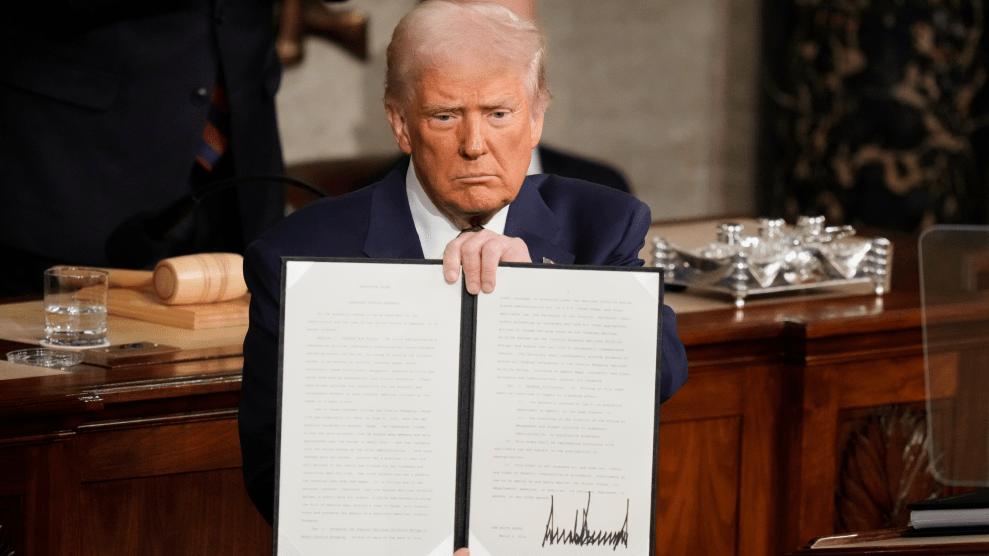 President Donald Trump holds up a signed executive order in front of the joint session of Congress on Tuesday, March 4, 2025.
