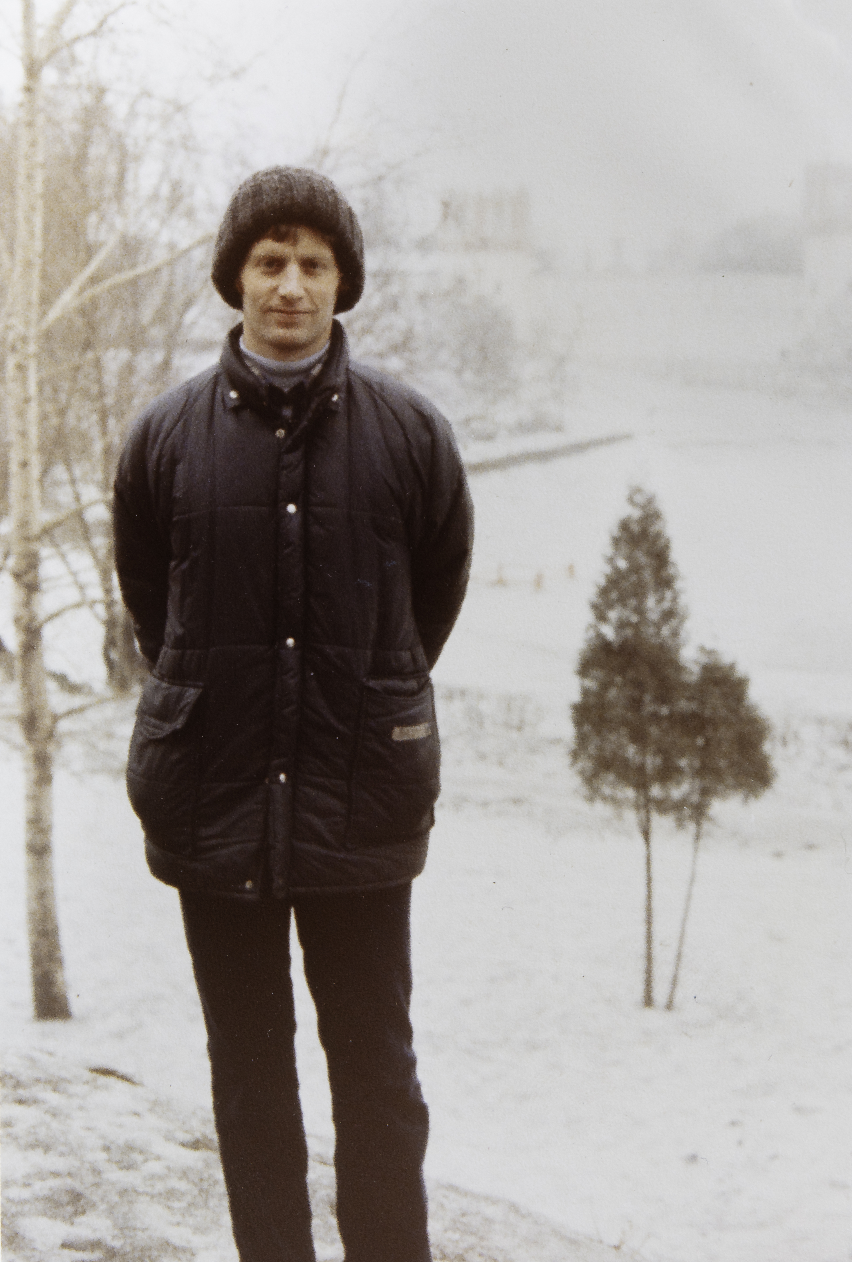 Archival image of Jeffrey Klein as a young journalist, a tall man with red hair wearing winter clothing and looking straight at the camera amid snowy surroundings.