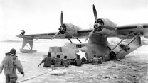 A black and white photo of a plane stuck in ice.