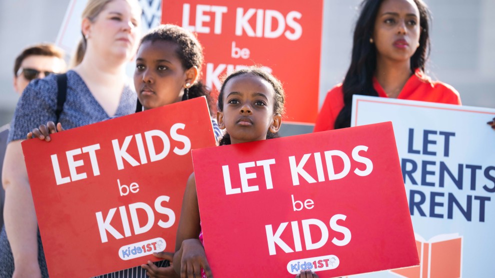 Four protesters hold signs reading "let kids be kids" and "let parents parent"