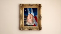 A framed portrait of Donald Trump hanging upside down on a beige wall.