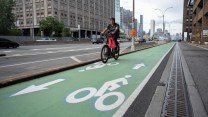 A person biking on a green bike path in New York City