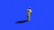 Photo illustration of an immigrant detainee wearing an ICE jumpsuit and standing all alone on a blue background, seemingly abandoned.