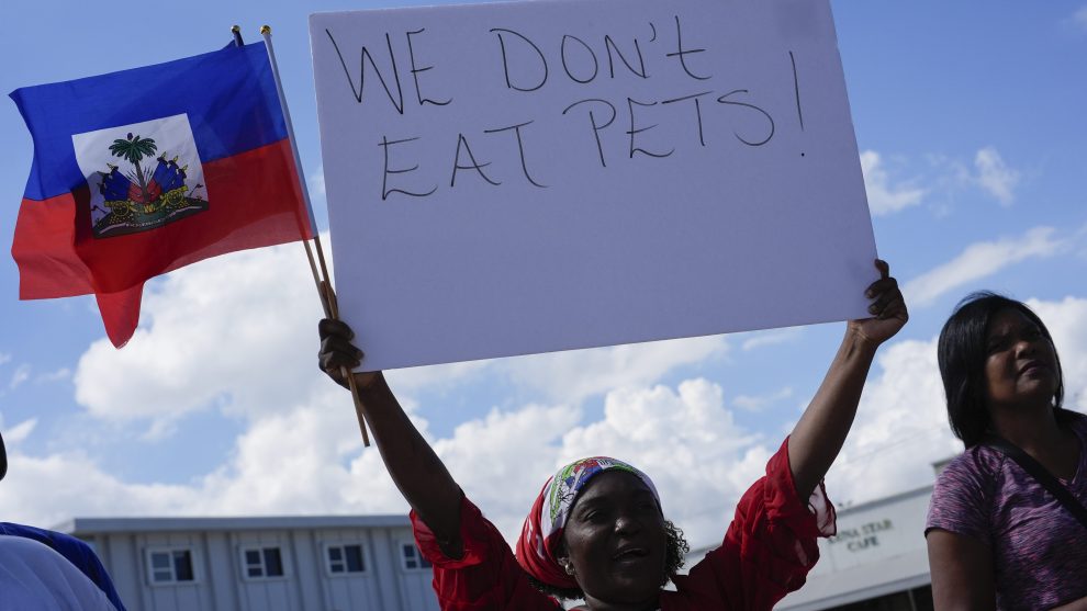 A Haitian woman holds a sign at a protest