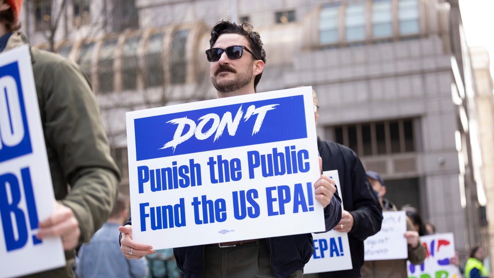 A white person with short brown hair holds a sign that says "Don't punish the people Fund US EPA"