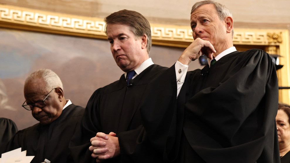 Three Supreme Court justices stand in black robes, two appear to be bowing their heads.