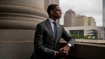 A Black man looks over a balcony