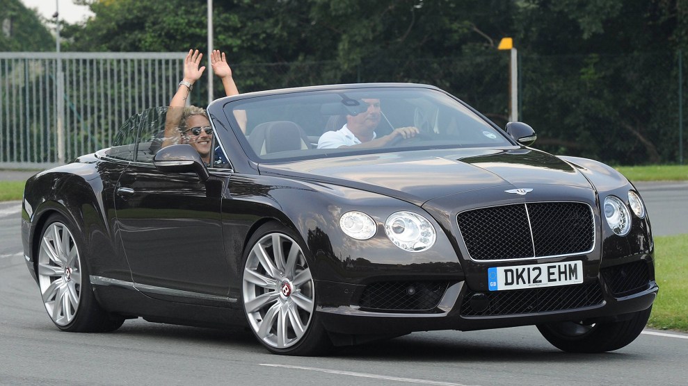Two men drive in a black convertible